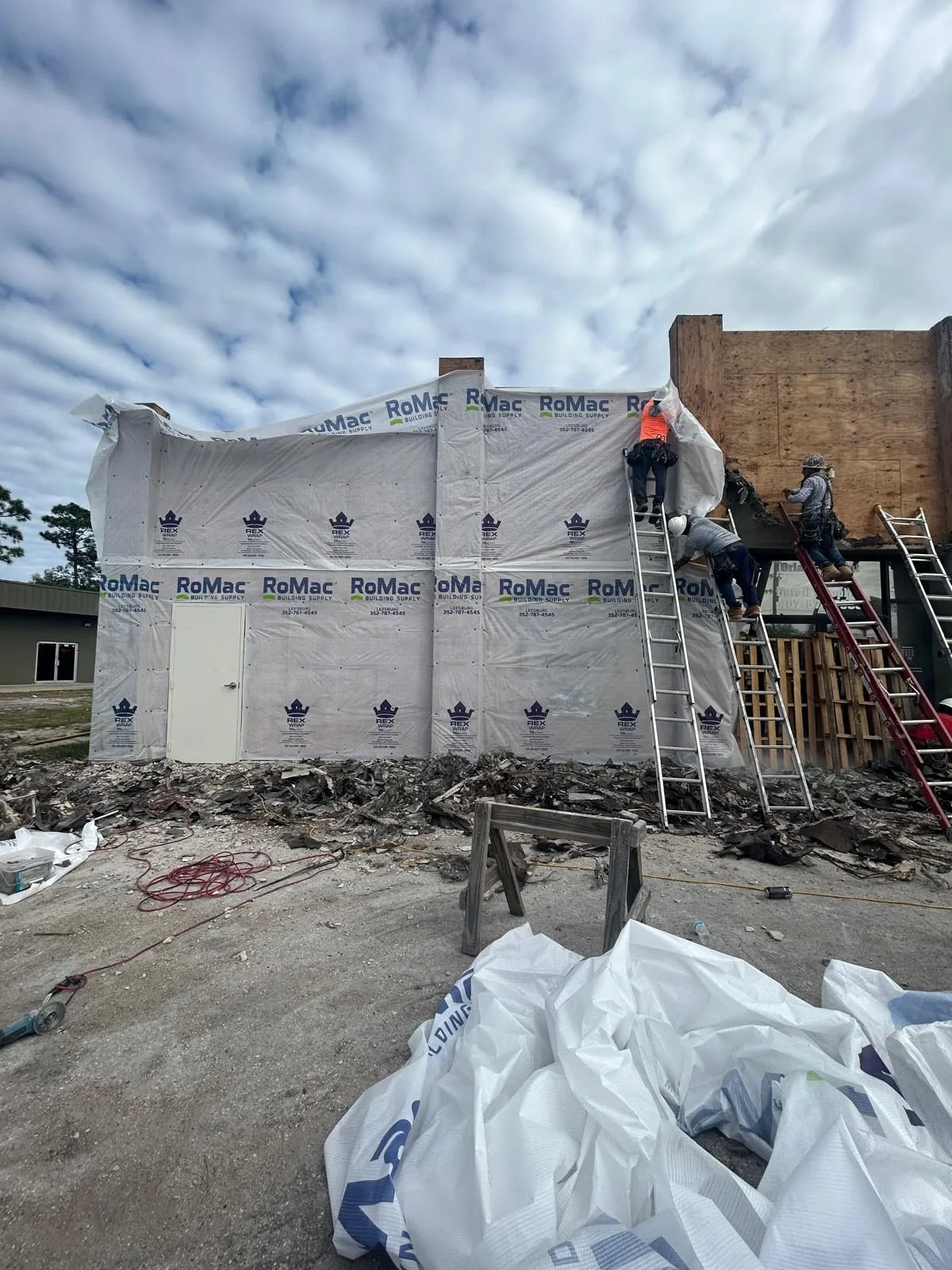 Endless Siding crew installing weather barrier before siding